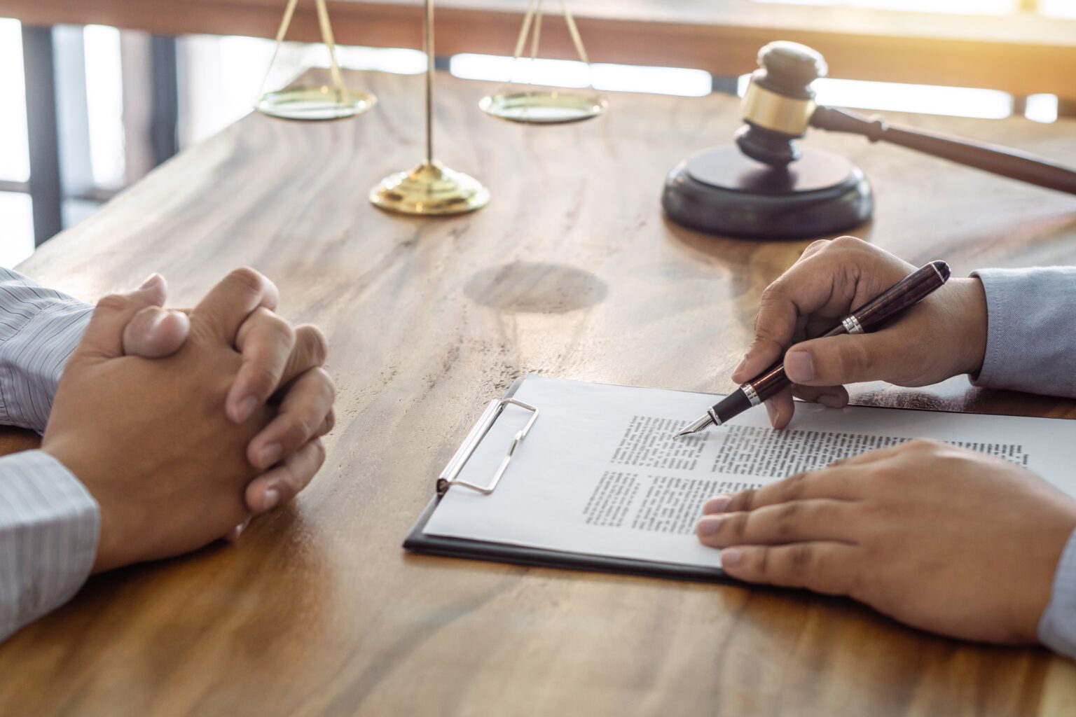 A lawyer consulting with a client across a desk during a legal consultation